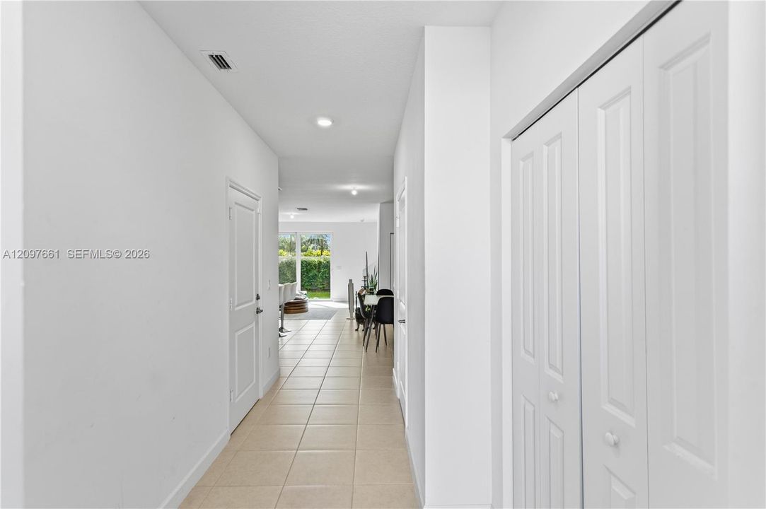 Hallway featuring ceramic tile flooring, recessed ceiling lighting, and crisp white interior doors, including a double-panel closet door
