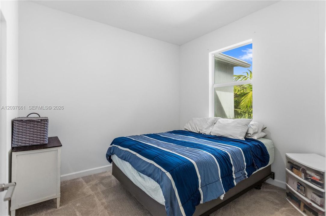 Neutral-toned carpeted flooring, white wall finishes, and a single-pane window
