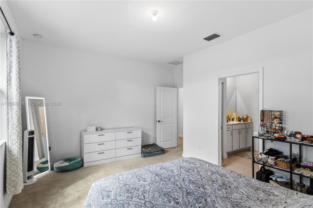 Neutral interior room with plush carpeting, recessed ceiling lighting, and a solid-core interior door