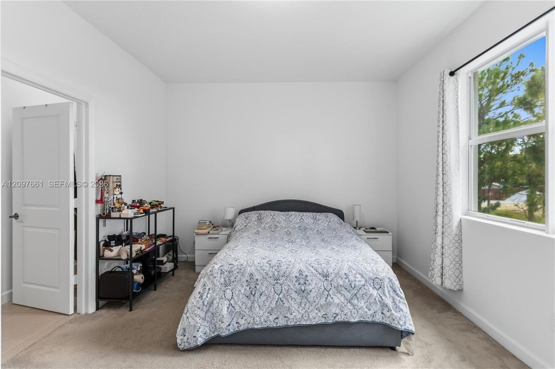 Interior room featuring wall-to-wall carpeting, neutral interior paint, and a single-hung window with exterior scenery