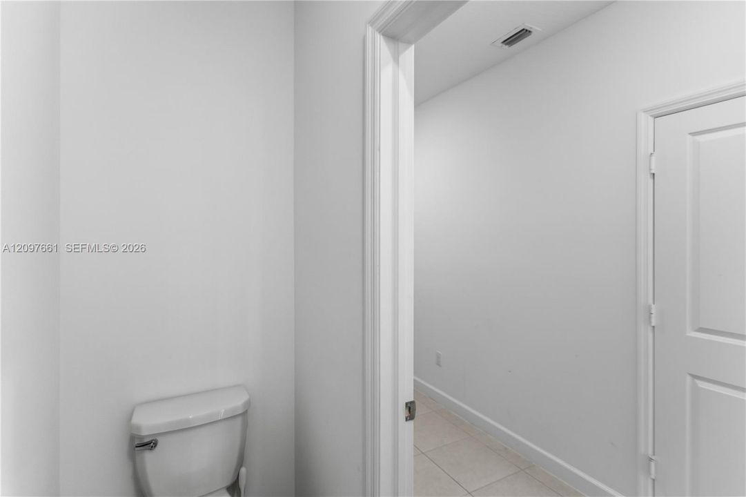 Interior space featuring white walls, tile flooring, and a two-panel interior door
