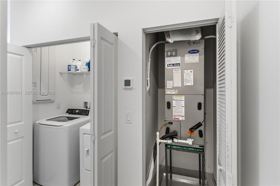 Utility area featuring a wall-mounted wire shelf and a dedicated HVAC closet