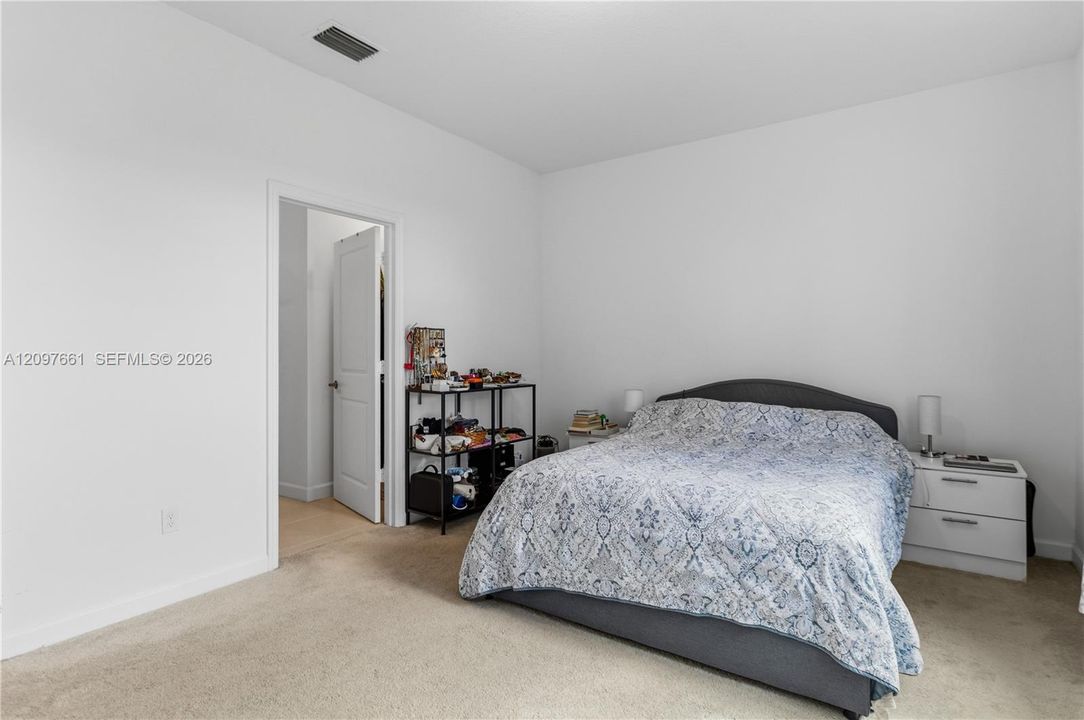 Neutral-toned carpeted flooring, high ceilings, and an interior paneled door
