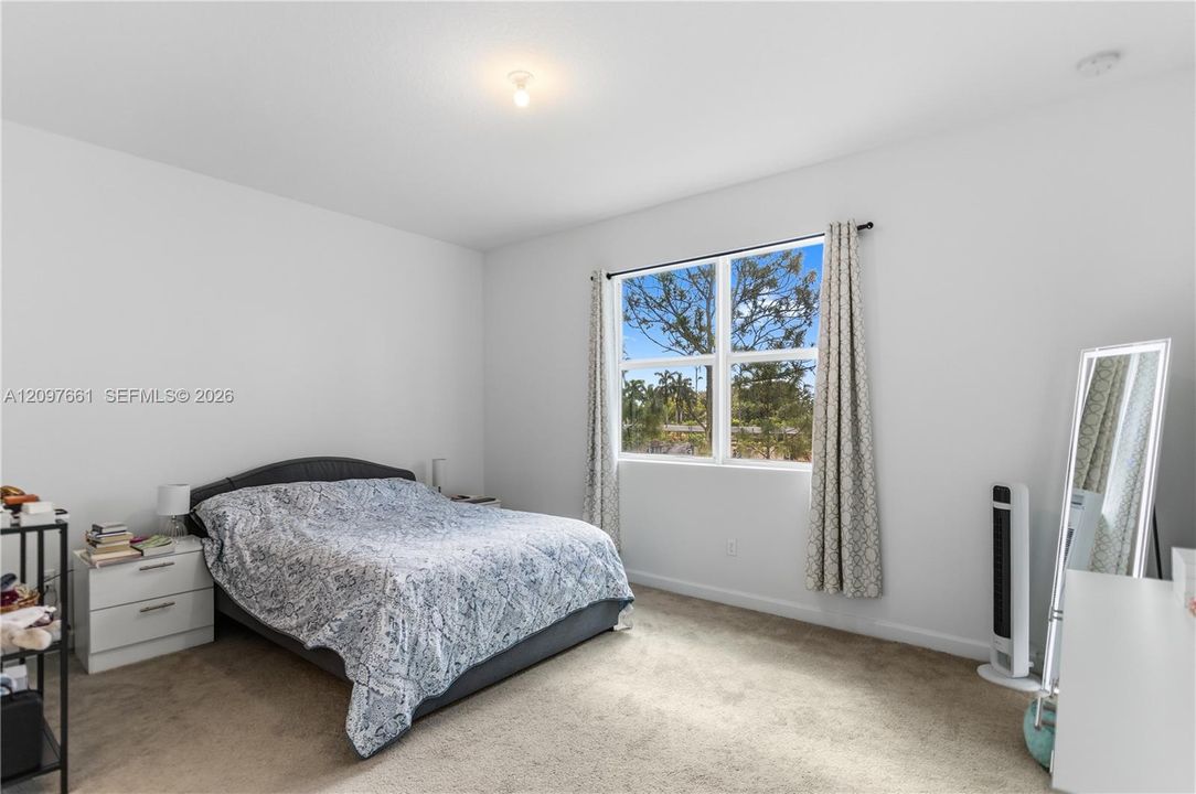 Neutral-toned interior space featuring neutral wall paint, wall-to-wall carpeting, and a multi-pane window