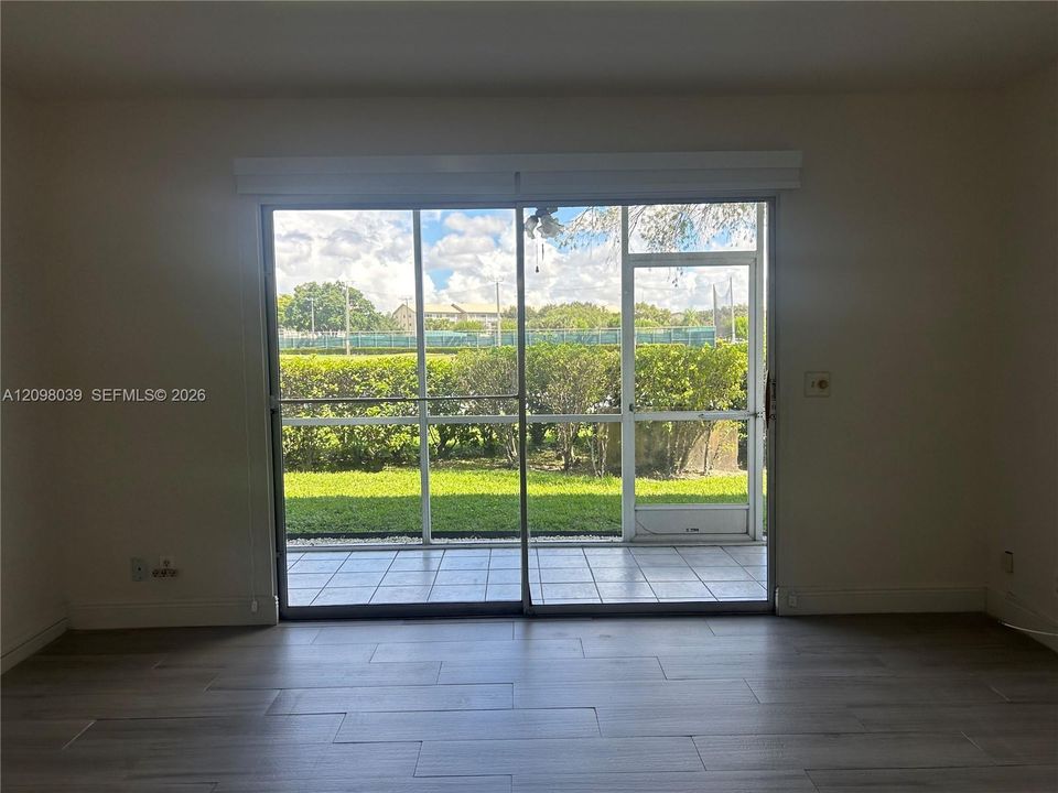 Wood-finish flooring, large sliding glass door, and screened-in patio with tile flooring