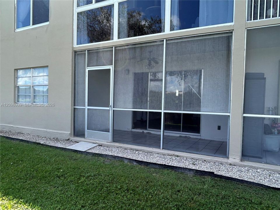 Screened patio featuring tile flooring, sliding glass door access, and a metal frame enclosure