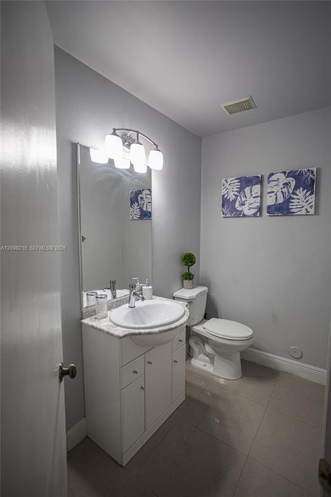 Guest bathroom with a white vanity and simple, timeless finishes.