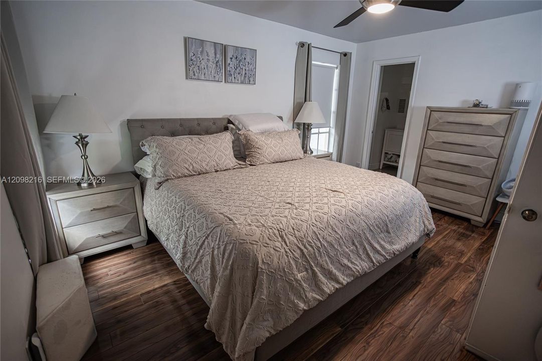Serene bedroom with wood style flooring, a ceiling fan and room for a full furniture suite.