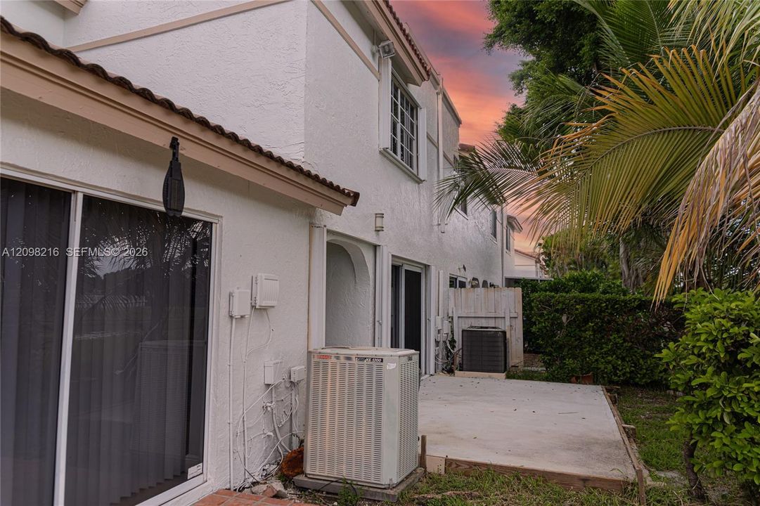 Side exterior with a private patio and sliding glass access.