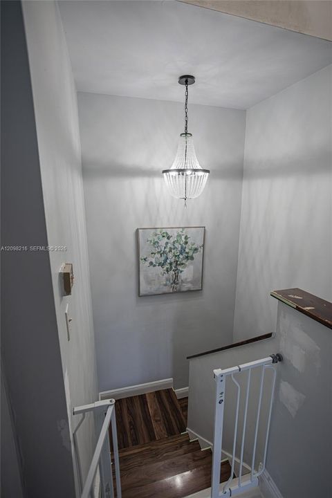 Upstairs landing with a pendant light and an open railing.