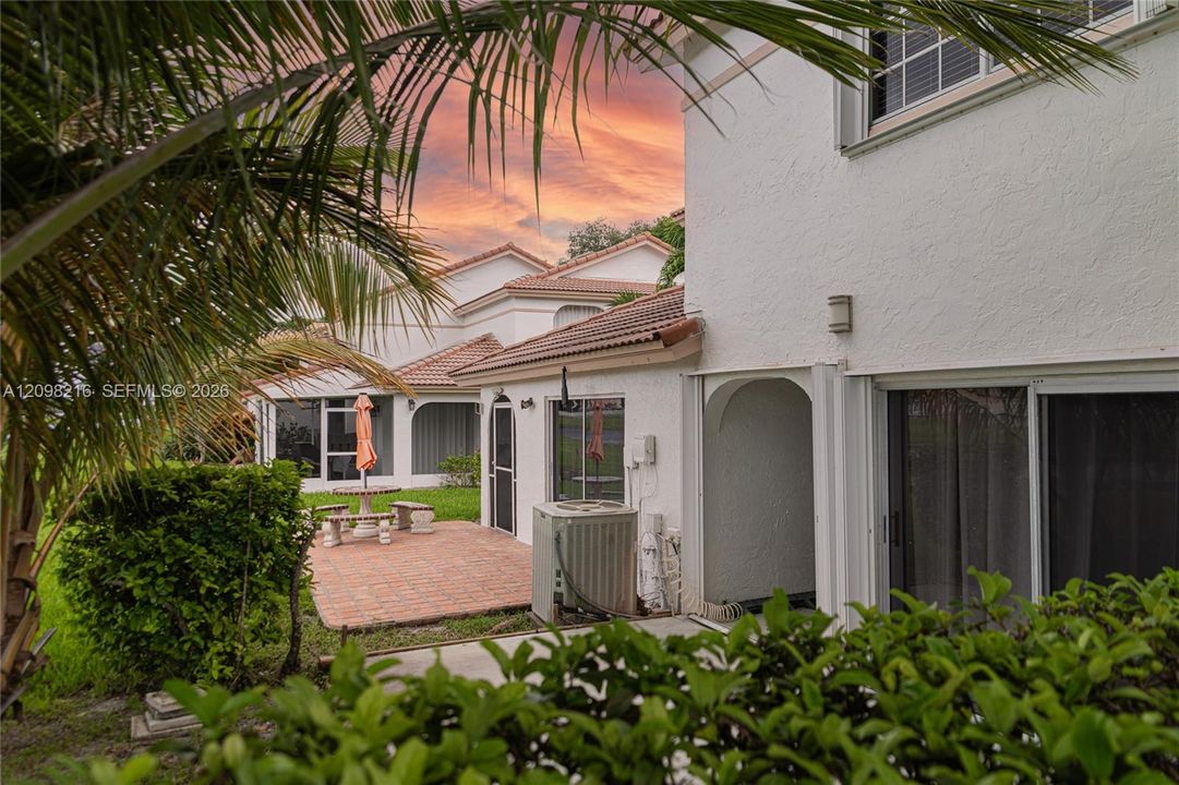 Rear exterior with private patio and lush, layered landscaping.