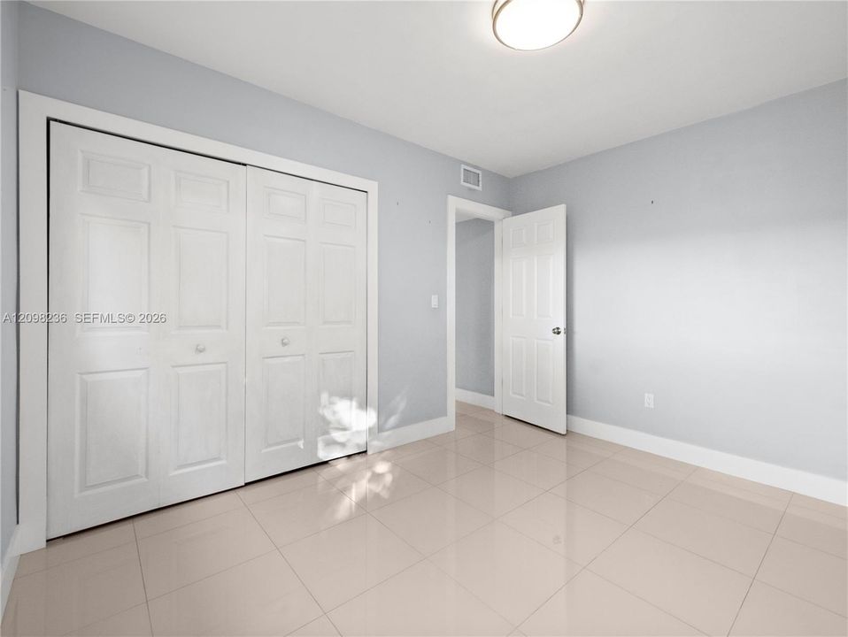 Bedroom view showing the room's layout, window, and closet area.
