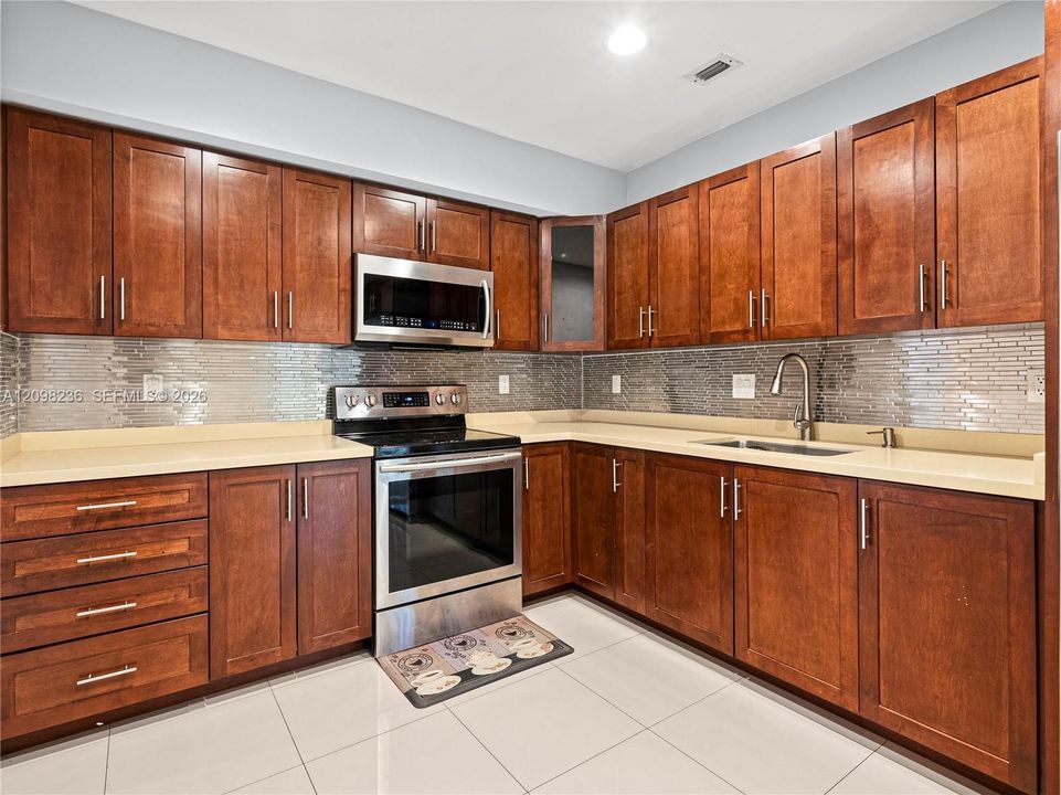Additional kitchen view showcasing the cabinetry, stainless-steel appliances, and counter space.