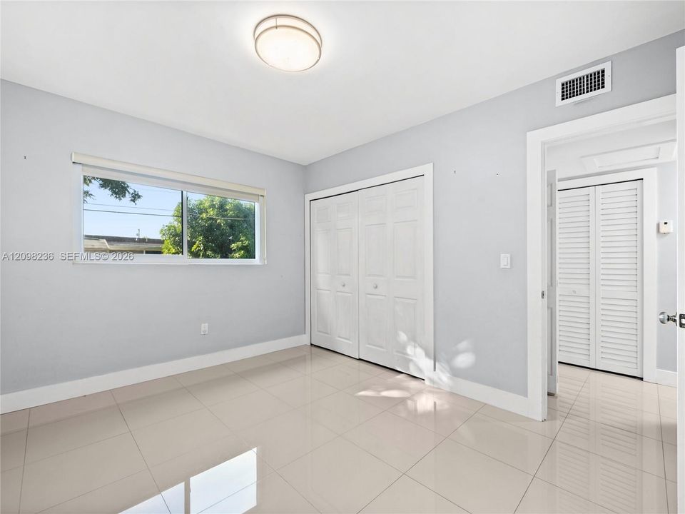 Additional bedroom view highlighting the room's natural light and usable space.