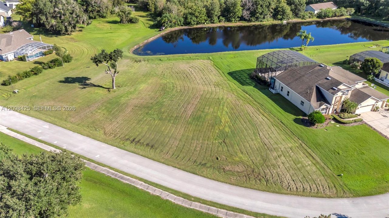 Expansive waterfront parcel featuring a grass lawn and direct pond access