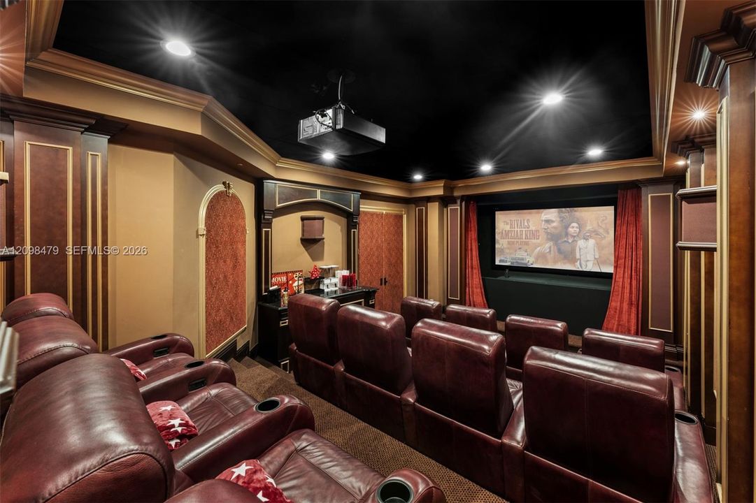 Dedicated home theater featuring a large projection screen, integrated projector, and recessed lighting