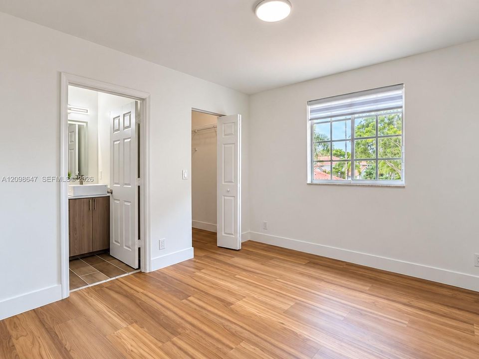 Versatile secondary bedroom with new waterproof laminate floors, clean lines, and abundant natural ligh
