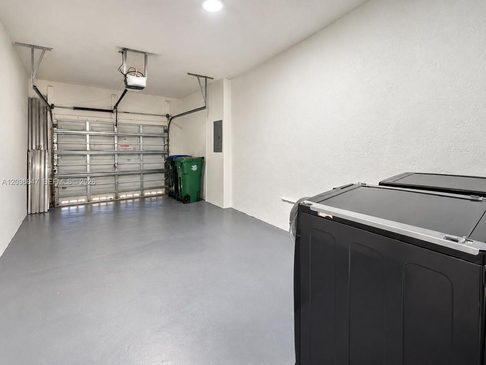 Clean, freshly finished single-car garage with immaculate floor coating and extra storage space.