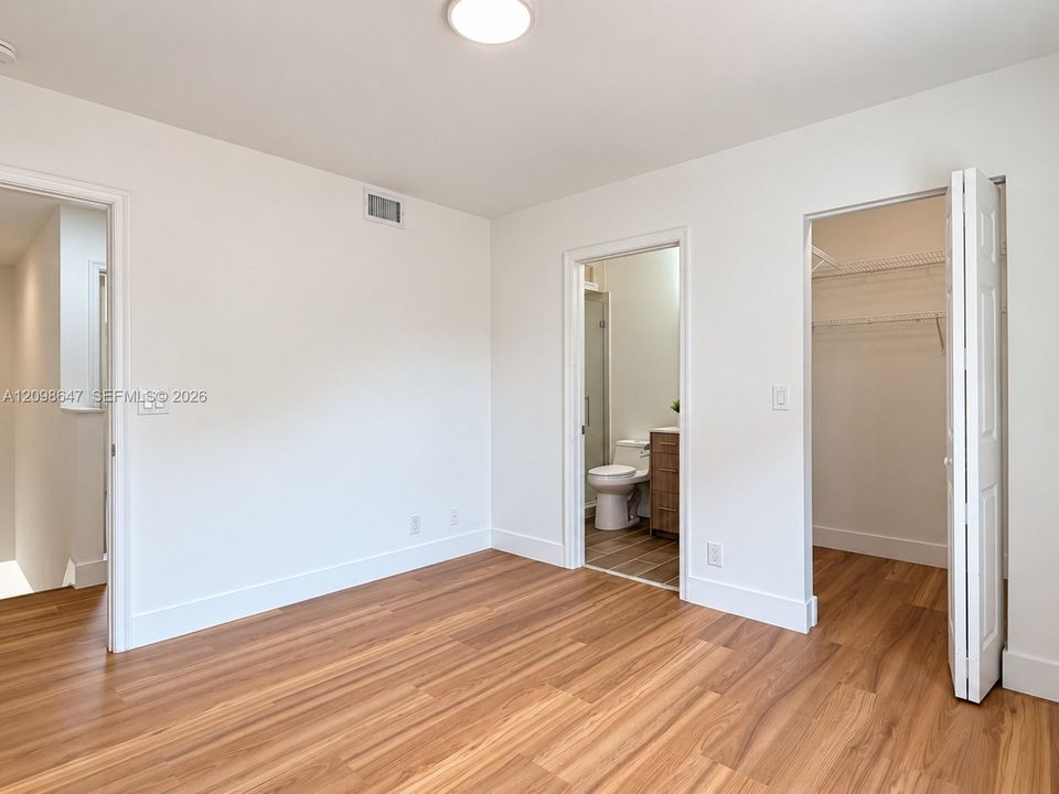 Spacious bedroom completely updated with brand-new waterproof laminate flooring, fresh paint, and bright windows.
