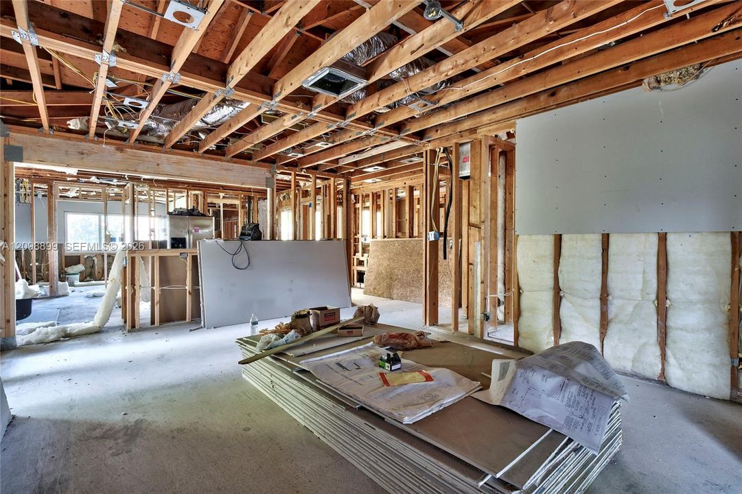 Open-concept structural layout featuring exposed timber framing, concrete flooring, and insulated wall panels
