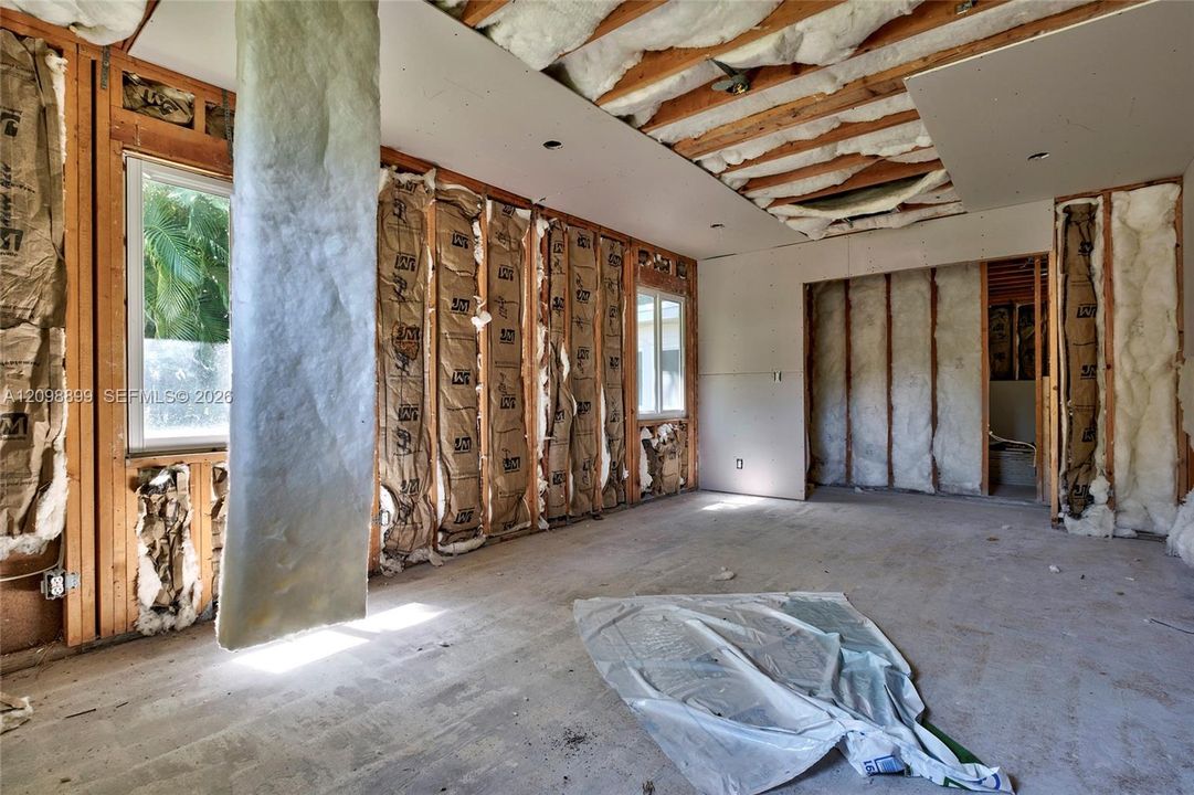 Interior space featuring exposed wood framing, installed batt insulation, and dual-pane windows