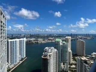 High-rise urban landscape featuring expansive water expanses, multi-story residential towers, and bridge infrastructure
