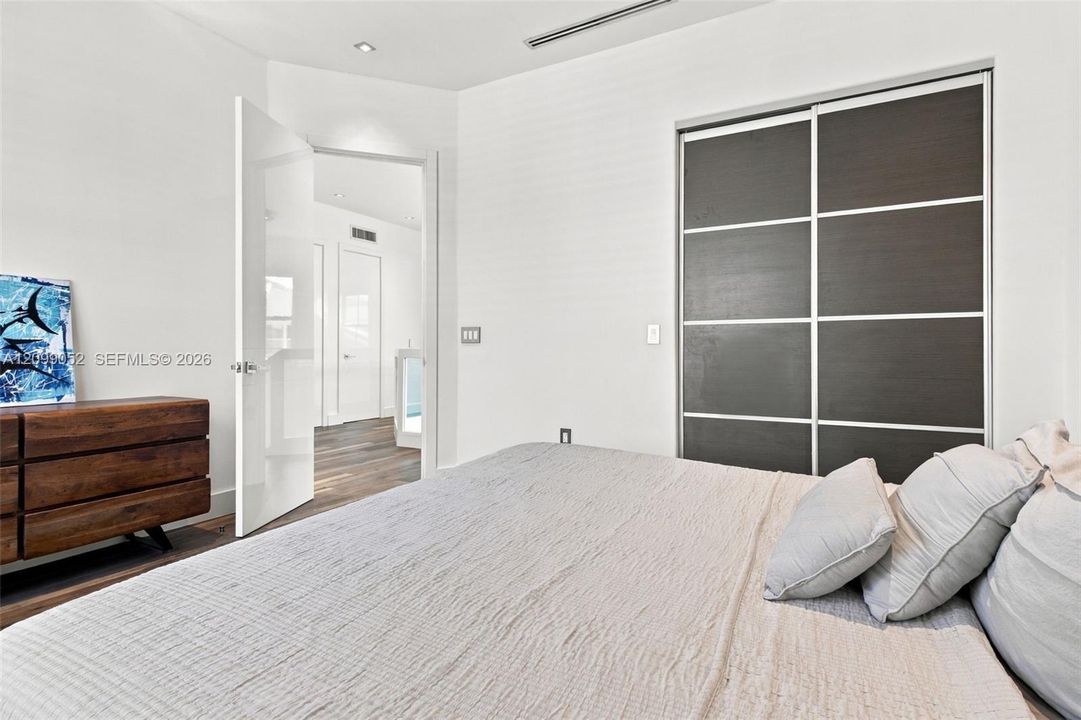 Sliding closet doors with dark wood-finish panels, recessed ceiling lighting, and crisp white walls