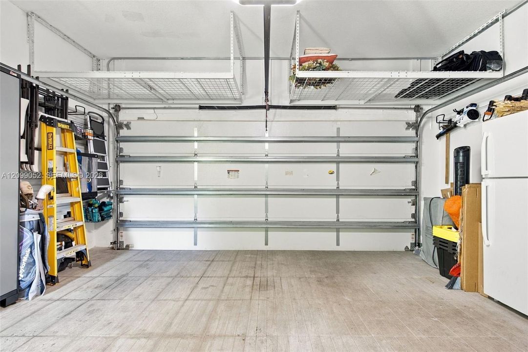 Garage featuring overhead metal storage racks and concrete flooring