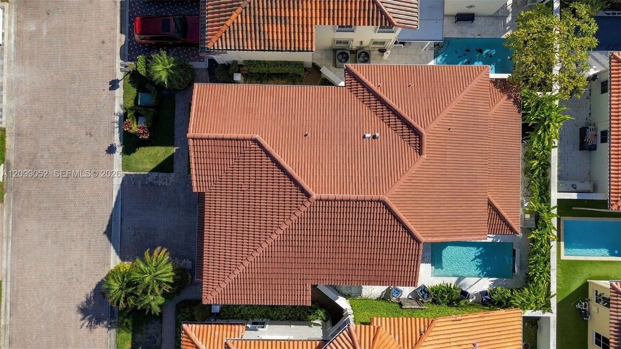 Aerial perspective featuring a tile roof, private swimming pool, and landscaping