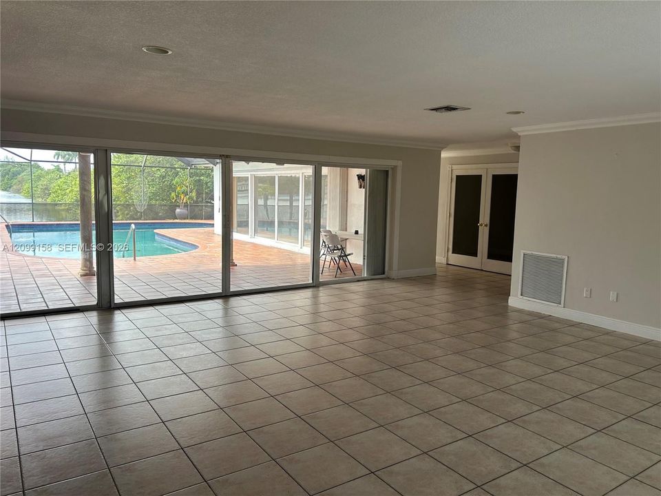 Large-format sliding glass doors, ceramic tile flooring, neutral wall palette, and recessed lighting