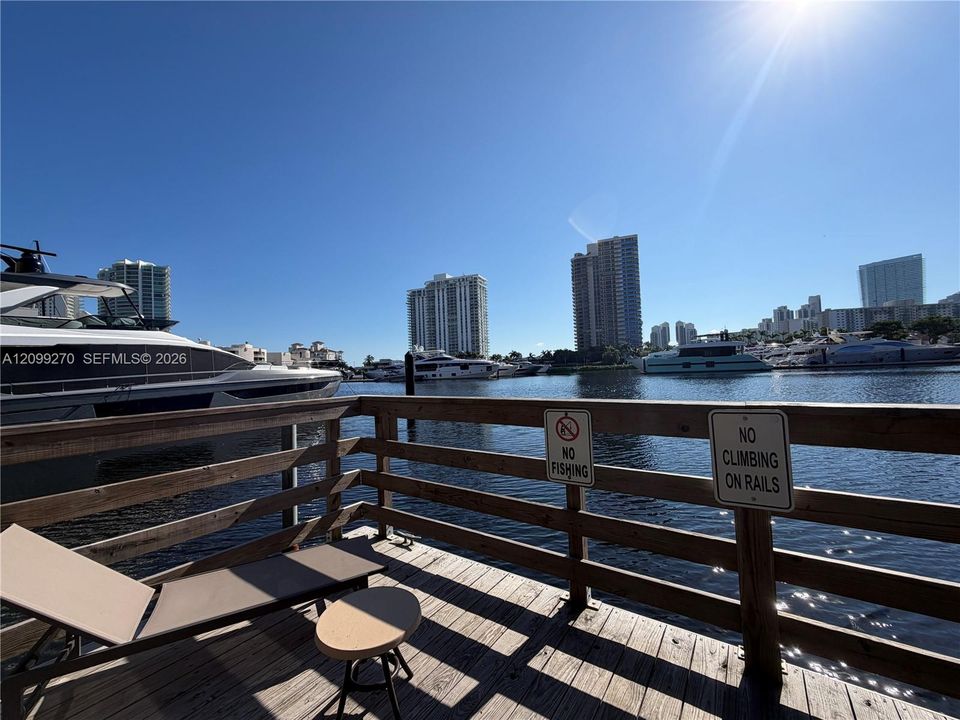 Waterfront wooden deck featuring perimeter railing and direct waterway access