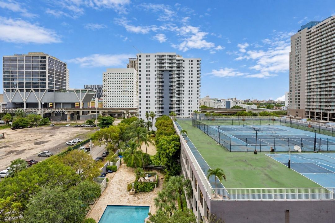 Enjoy scenic views of the surrounding city skyline, waterfront, and community amenities, including the swimming pool and sports courts.