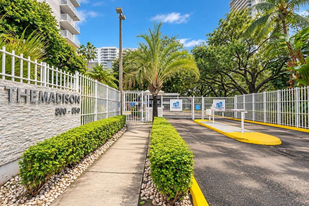 Welcome to The Madison, featuring a gated entrance, controlled access, and beautifully landscaped grounds with lush tropical greenery.