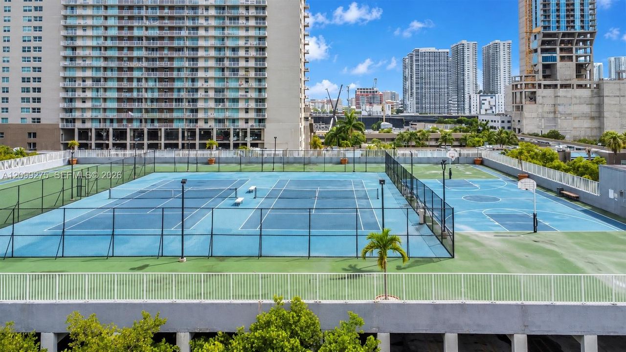 Recreational amenities featuring tennis courts, basketball courts, and panoramic views of Miami’s high-rise skyline.