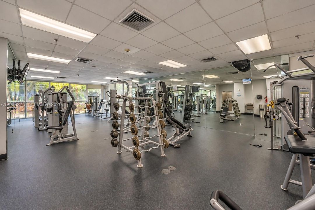 Well-equipped fitness center featuring a variety of strength-training machines, free weights, and mirrored walls, providing residents with a convenient space to maintain an active lifestyle.