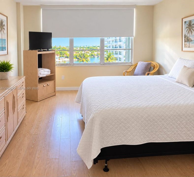 Large window featuring expansive water and landscape scenery, neutral wall tones, and wood-finish flooring