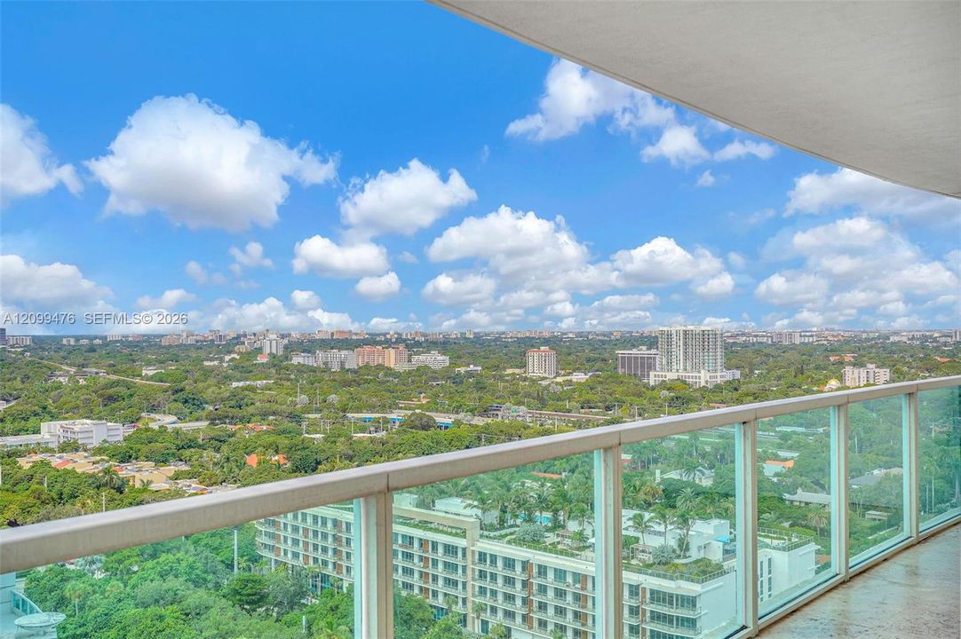 Private balcony featuring a glass-panel railing and concrete flooring