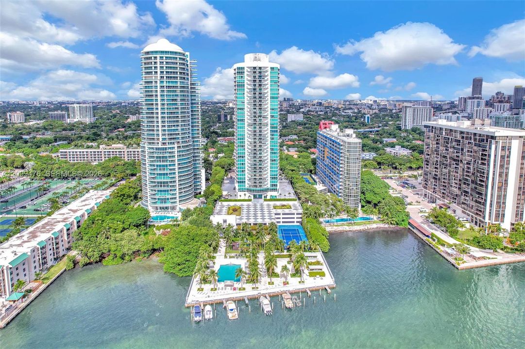 High-rise residential towers featuring waterfront access, private boat slips, an outdoor swimming pool, and dedicated tennis courts