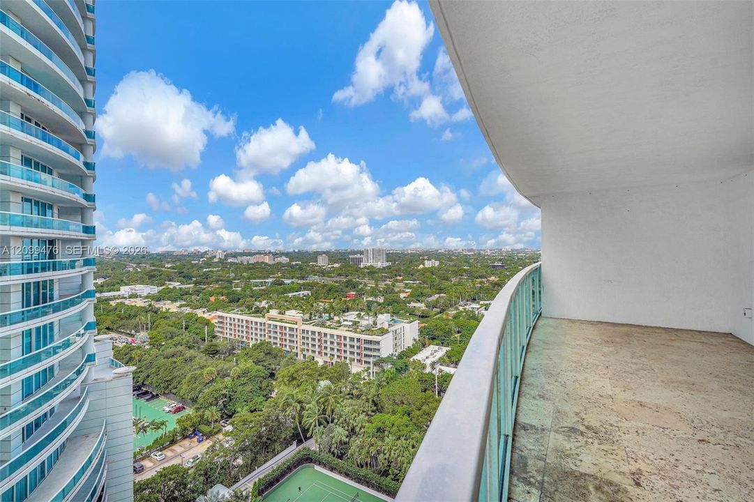Private balcony featuring stone flooring and metal-framed glass railings