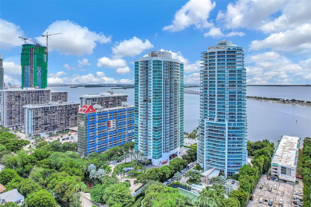 High-rise urban towers featuring glass facades, multiple balconies, and coastal proximity