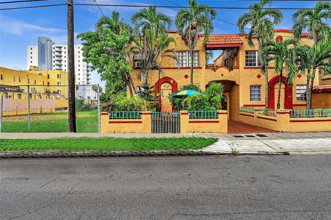 Multi-unit structure featuring a stucco exterior with arched doorways and terracotta roof tiles