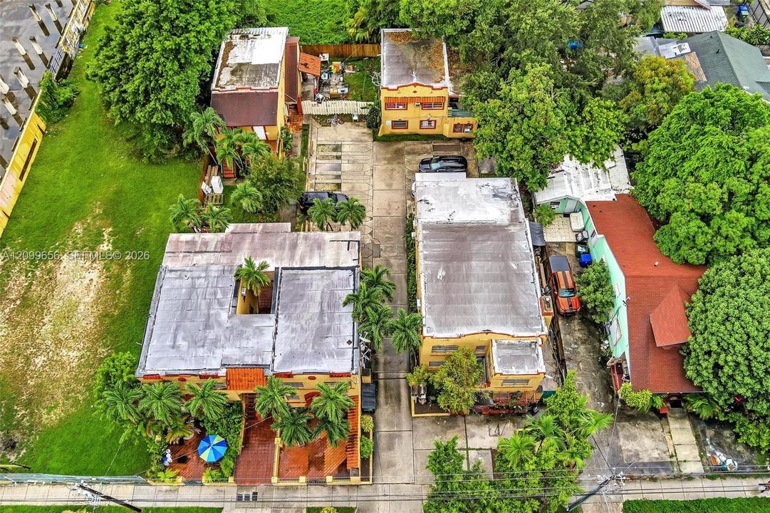Multiple two-story structures with flat roofs, paved parking areas, and mature landscaping