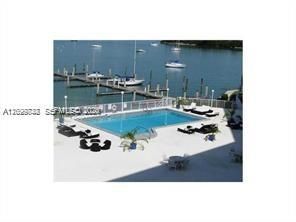 Rectangular swimming pool with surrounding concrete deck, safety enclosure, and integrated lighting