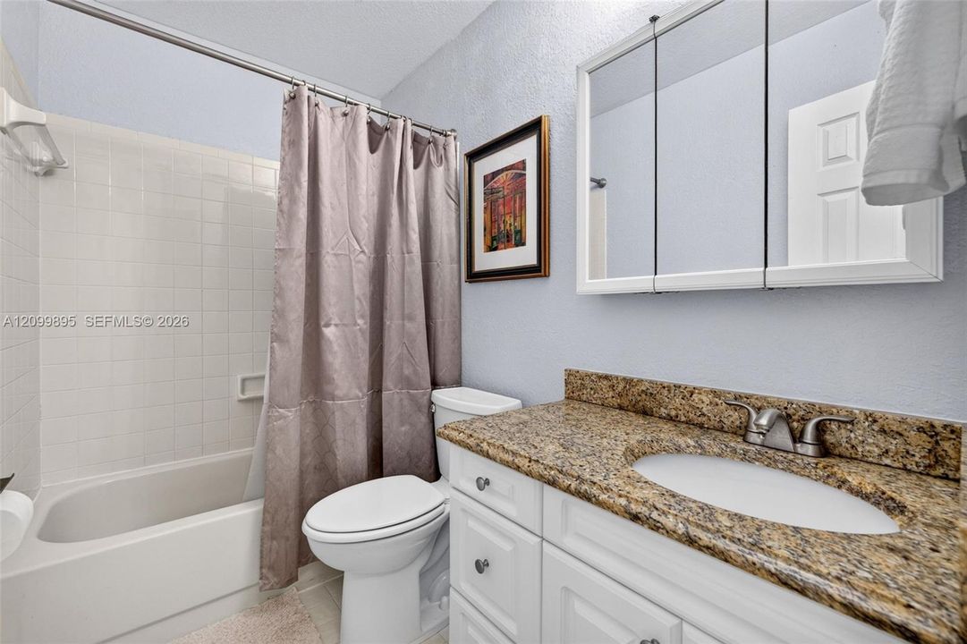 Well-maintained bathroom with a clean and functional design & granite counter.
