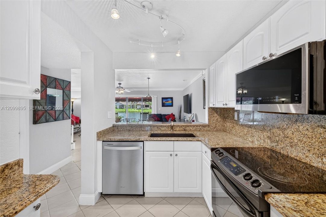 Well-equipped kitchen featuring granite counters, ample cabinetry, a pantry and a convenient breakfast area.