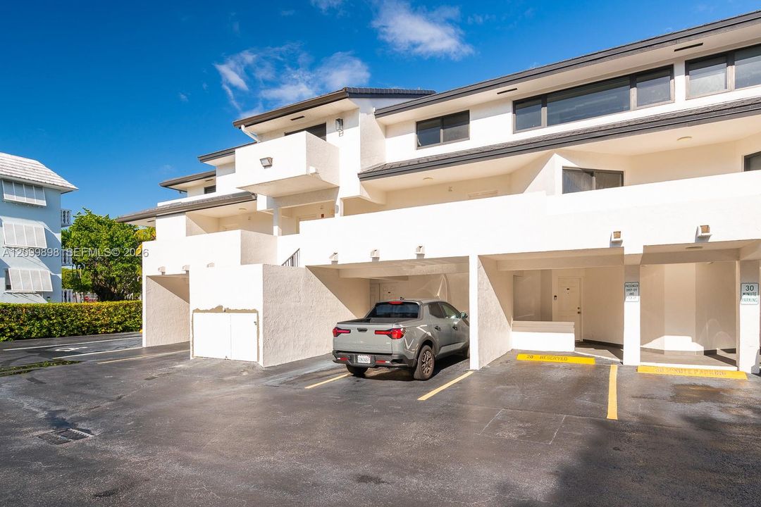 Unit 206 parking space # 20 is shown in this picture to the right of the gray car. Notice that the building shields about 1/2 of the car from our tropical weather! The Balcony you see to the left of the parking space is the balcony to the Primary bedroom located on the South side of the building overlooking a quiet residential neighborhood!!