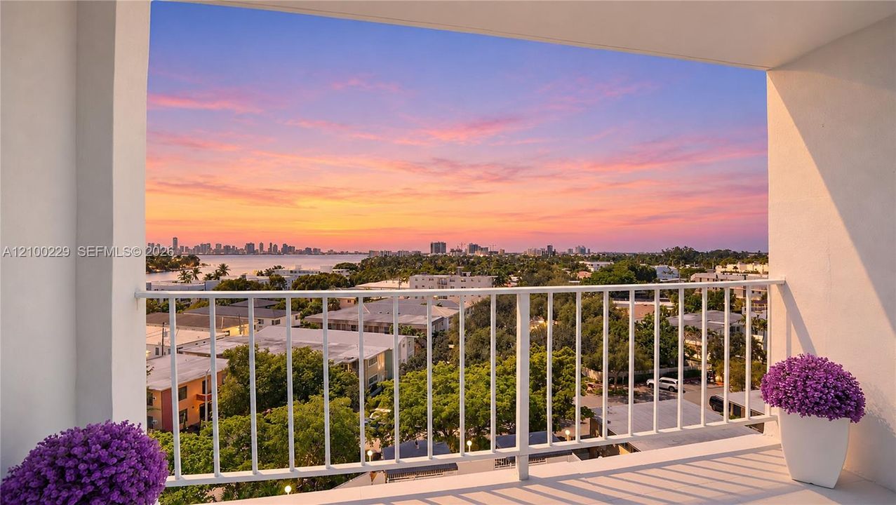 Covered outdoor terrace featuring a white metal railing and panoramic coastal city skyline backdrop