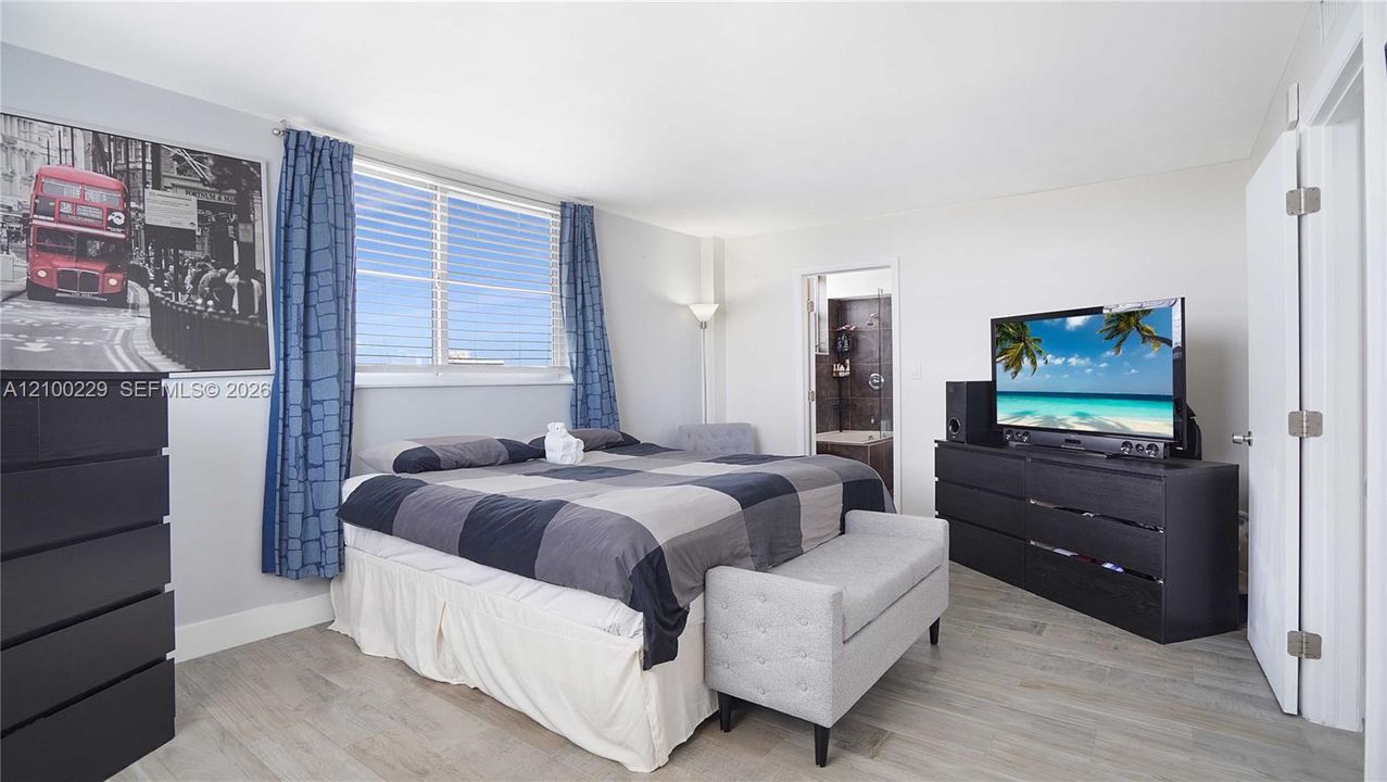 Bedroom featuring wood-finish flooring and a multi-pane window