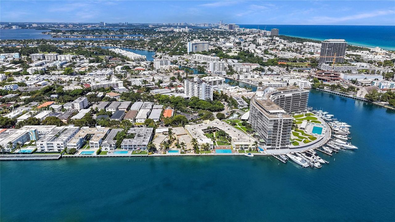 Aerial perspective of waterfront properties featuring deep-water dockage, multiple swimming pools, manicured green space, and proximity to the coastline