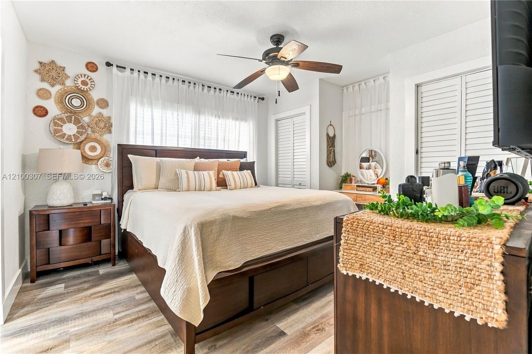 Wood-finish flooring, ceiling fan with integrated lighting, and plantation shutters